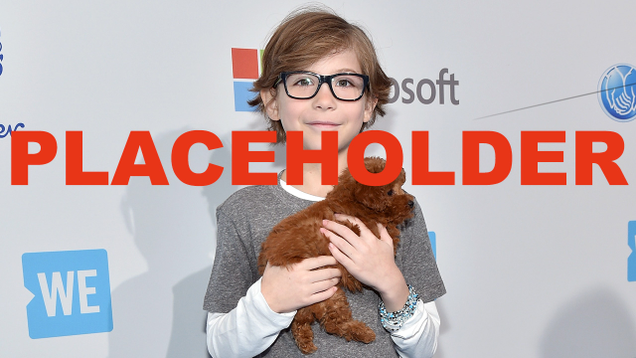 Jacob Tremblay holding a dog.